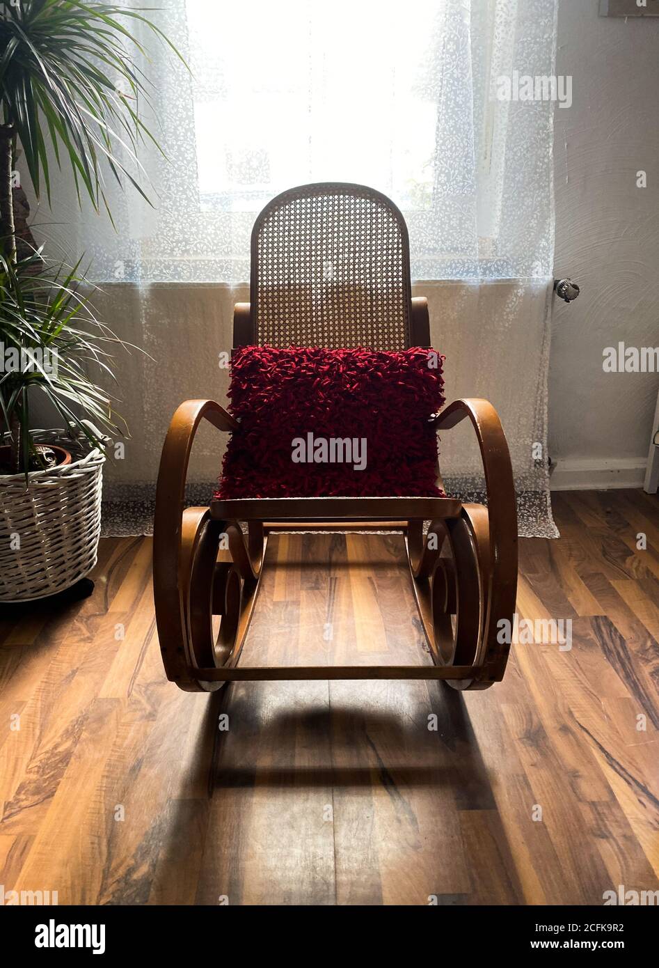 Vue sur une chaise à bascule vide dans la salle de séjour avec ombre du contre-jour de la fenêtre - le deuil et la perte de l'aimé concept de personne Banque D'Images