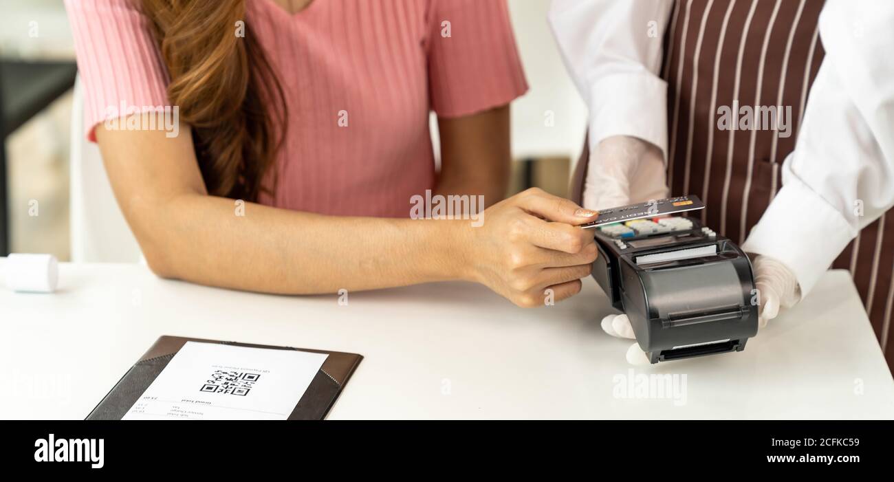 Panoramique gros plan asiatique femme client faire carte de crédit sans contact paiement après avoir mangé dans un nouveau restaurant social distance normal pour réduire le toucher Banque D'Images
