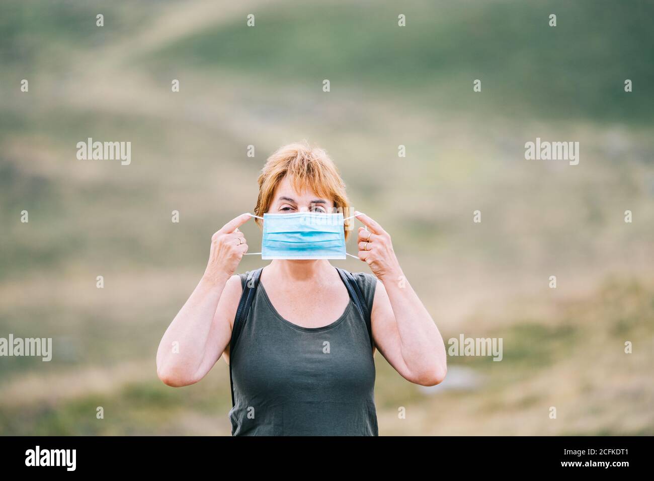 Femme voyageant mettant un masque médical sur son visage Banque D'Images