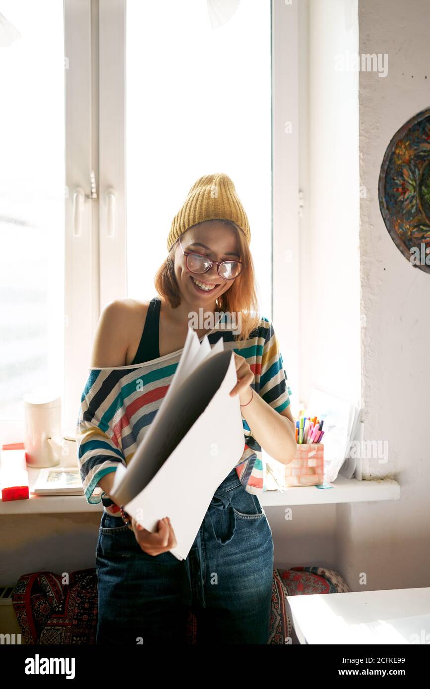 Vue laterale du contenu de la femme peintre dans une tenue originale avec fournitures d art en studio Photo Stock Alamy