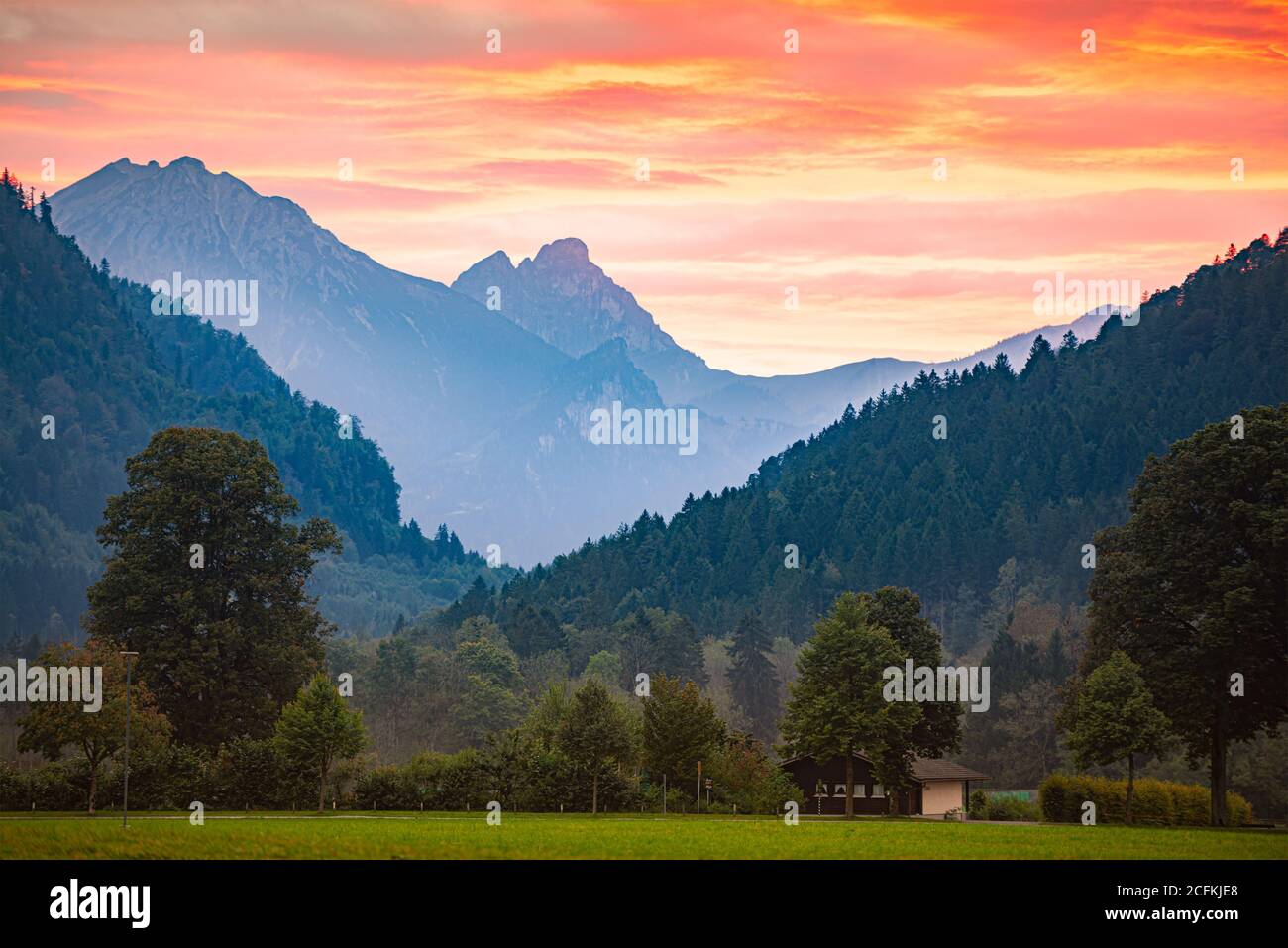 Montagnes en Bavière, Allemagne, Europe. Scène de coucher de soleil avec prairie en premier plan et ciel nuageux en arrière-plan Banque D'Images