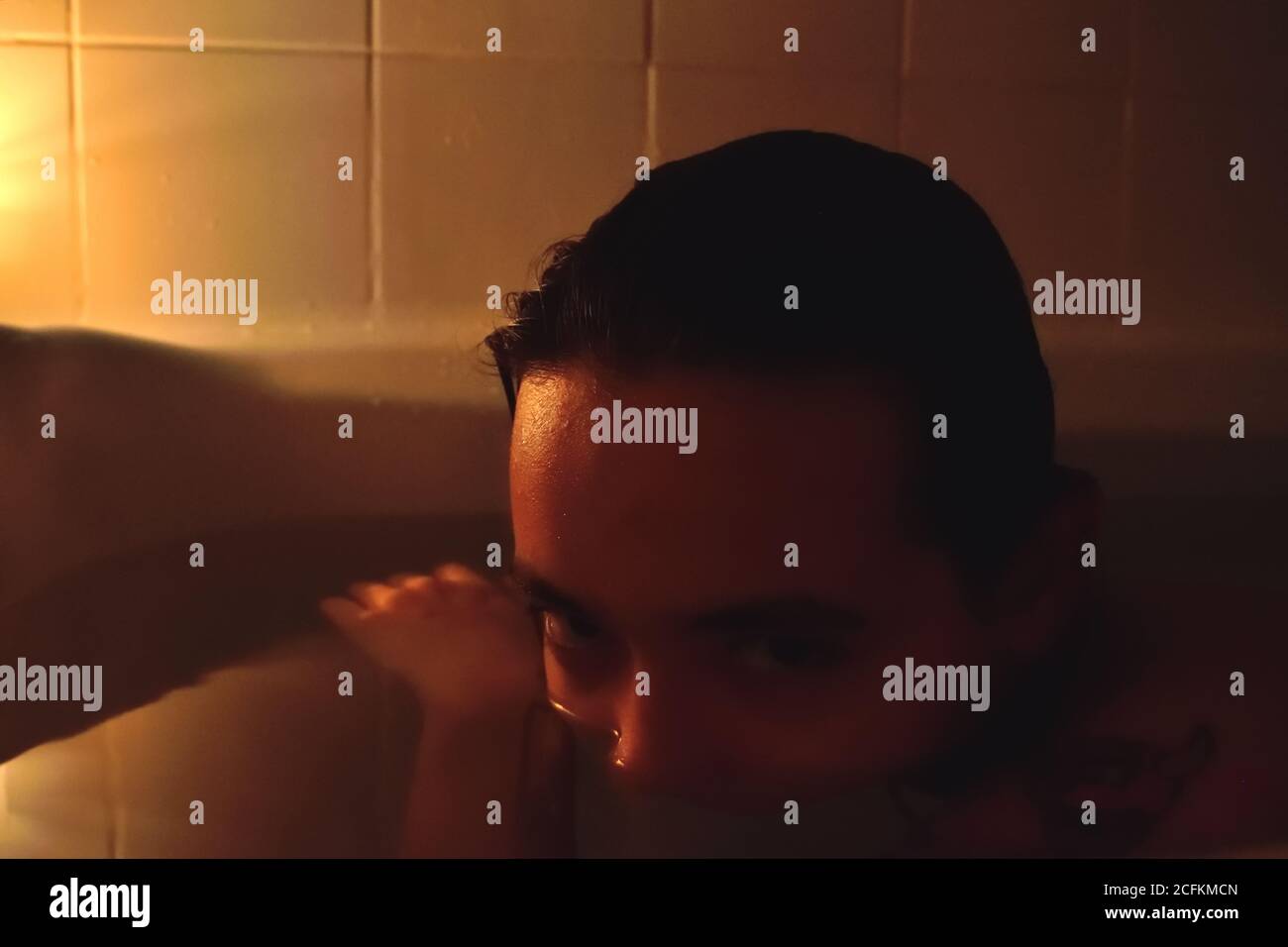 Personne dans la salle de bains avec moitié de visage dans l'eau Banque D'Images
