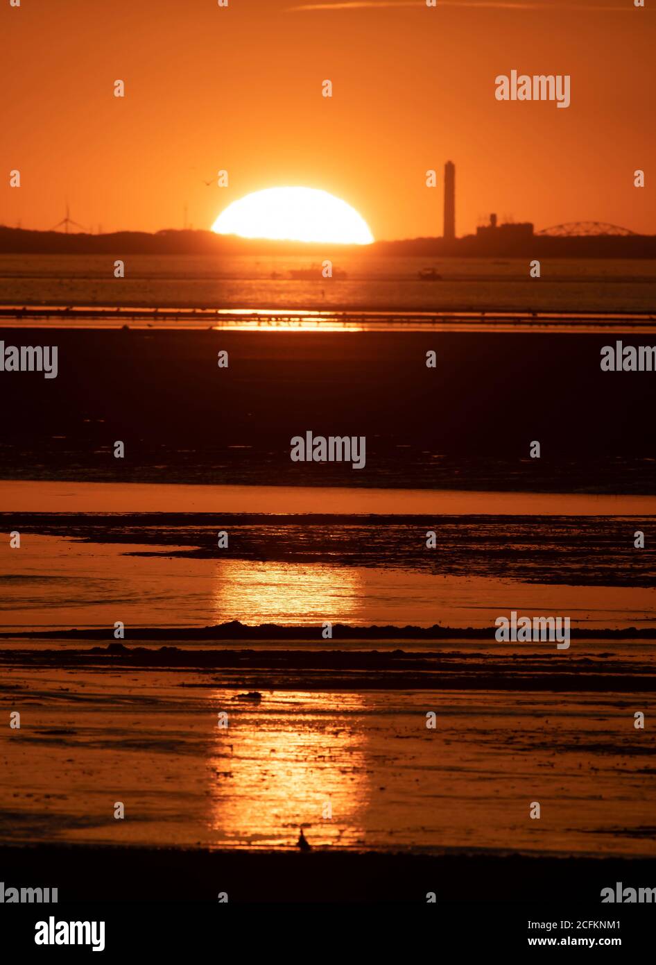 Le soleil se couche derrière une centrale électrique sur Cape Cod, un soir d'été. Banque D'Images