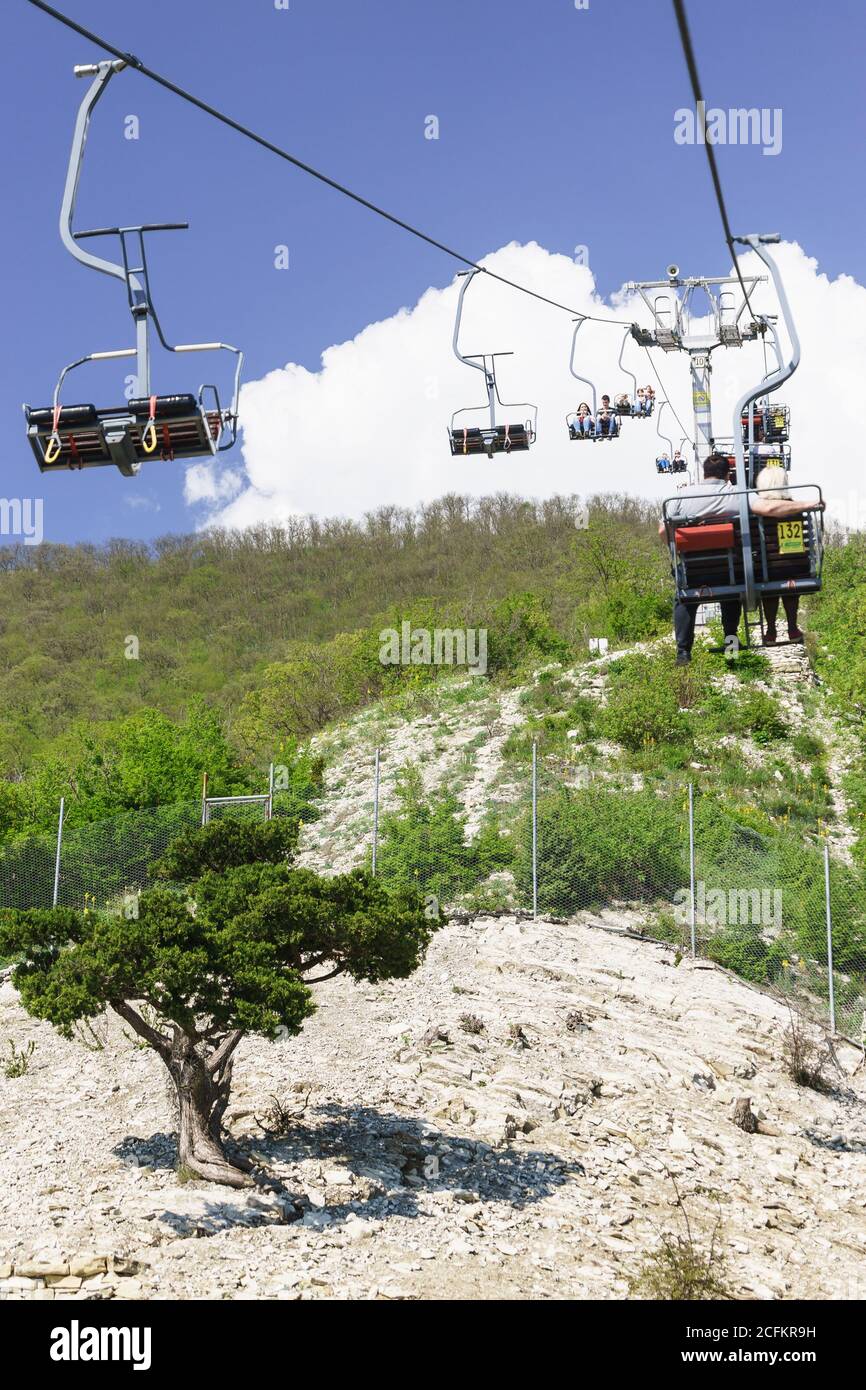 Gelendzhik, Russie - avril 30.2017 : les touristes grimpent sur le téléphérique au-dessus du printemps et de la pente de la chaîne de montagnes Markotkh dans le Safari Park. Banque D'Images