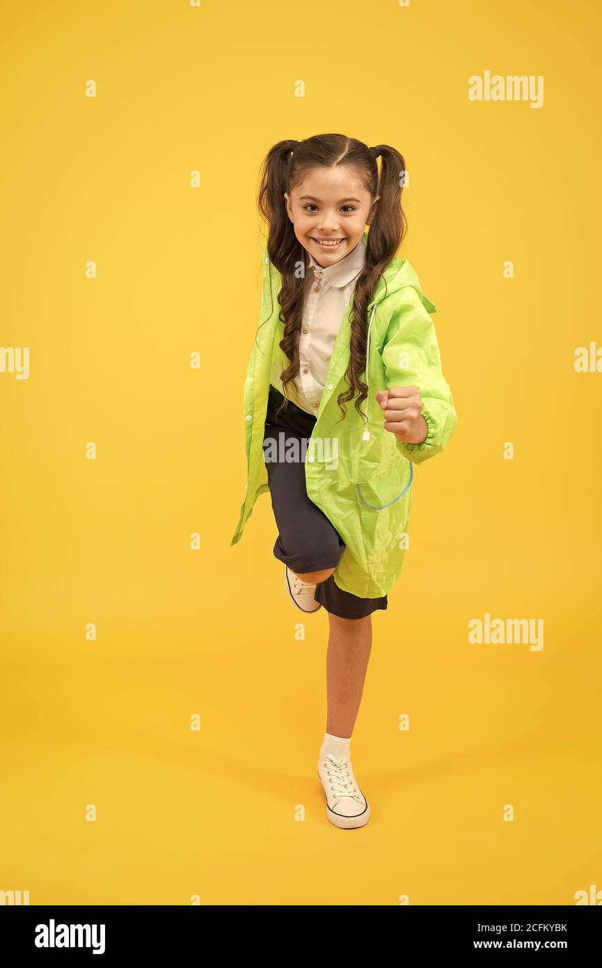 Lycéenne porter imperméable. Les enfants d'imperméables avec des dessins uniques. Lycéenne porter des vêtements résistant à l'eau. Jour de pluie. Jolie lycéenne se sentent protégés pour le printemps. Concept étanche. Banque D'Images