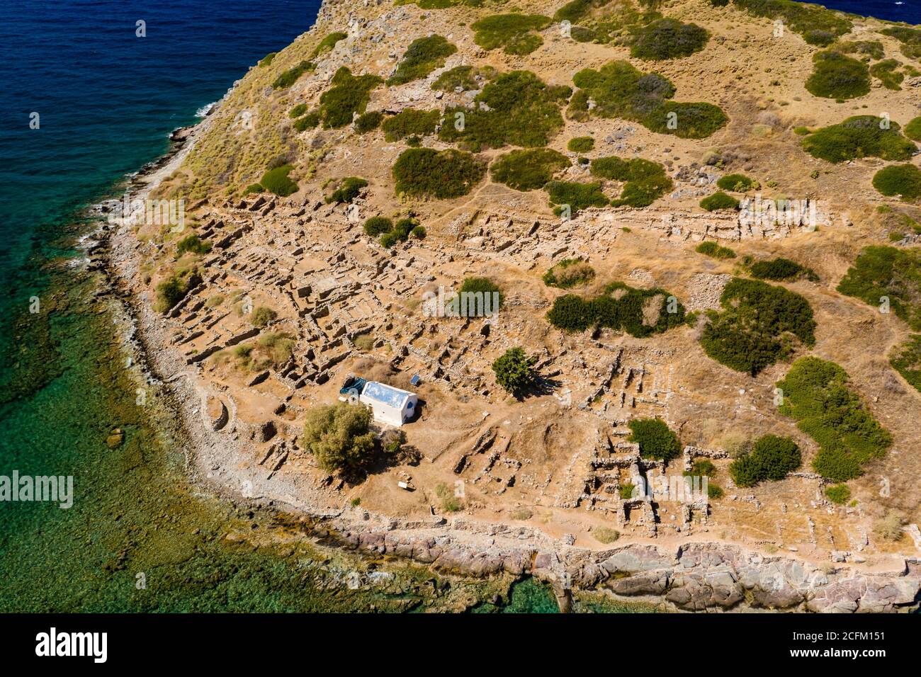Vue aérienne d'une ancienne ville portuaire de Minoan sur une île entourée d'un océan limpide (Mochlos, Crète, Grèce) Banque D'Images