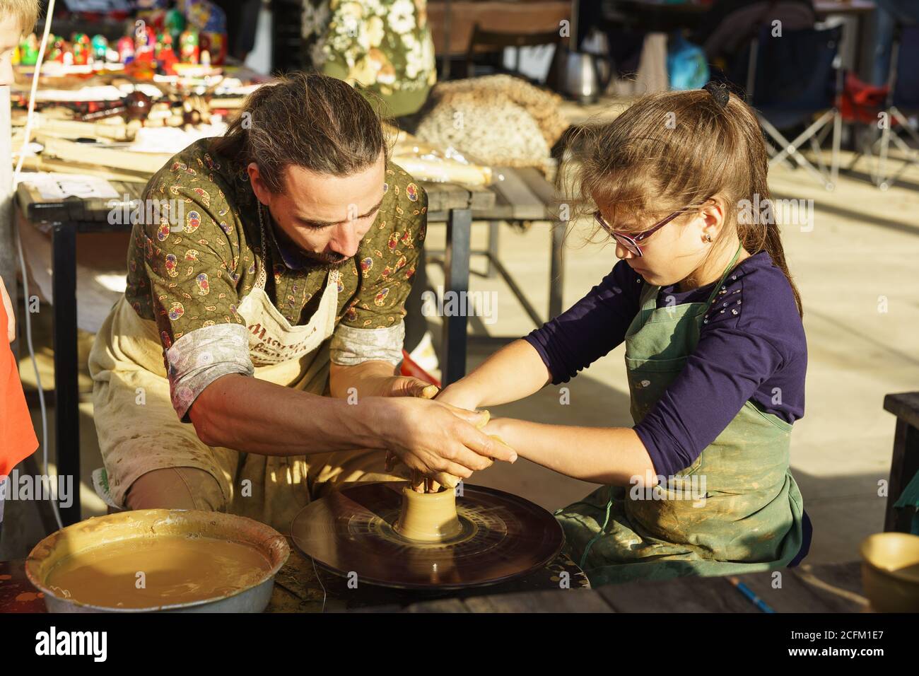 Moldavanskoye, Krymsk, Russie-05 octobre 2019 : un potier enseigne à une fille comment faire une carafe d'argile jaune. Cours de maître au festival du vin jeune de le Banque D'Images