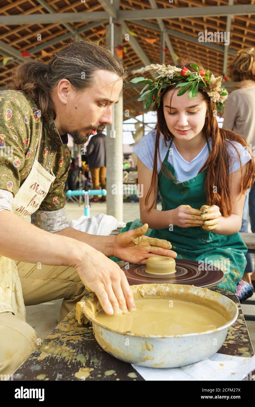 Moldavanskoye, Krymsk, Russie-05 octobre 2019: Un Craftsman montre à une fille comment faire un pichet à partir d'argile sur une roue de Potters. Classe de maître au festi Banque D'Images