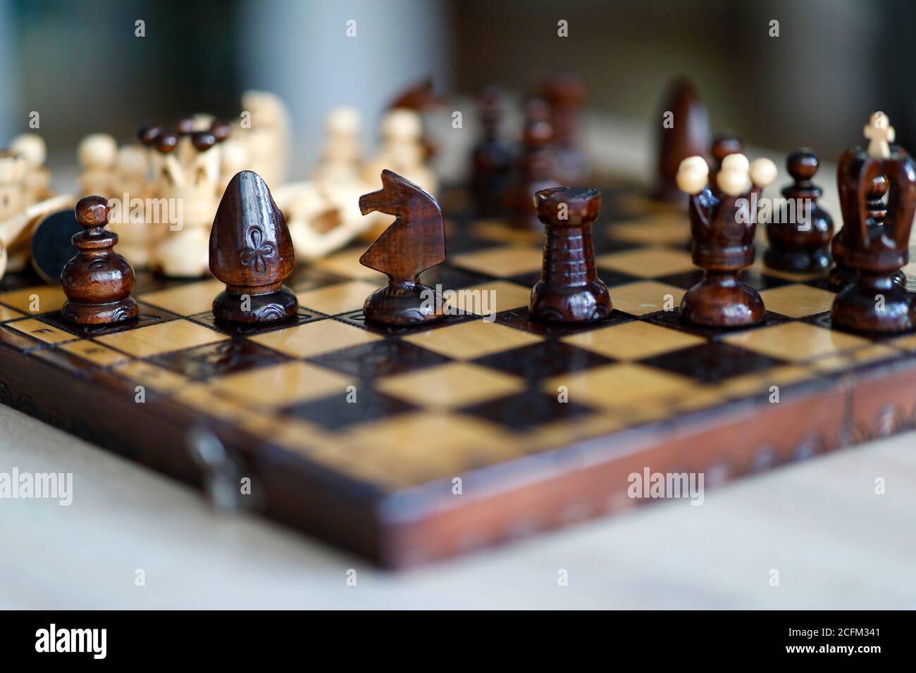 Pièces d'échecs sur une table de jeu en bois. Les pièces comprennent le pion, le roi, la reine, l'évêque, le chevalier et le rook Banque D'Images