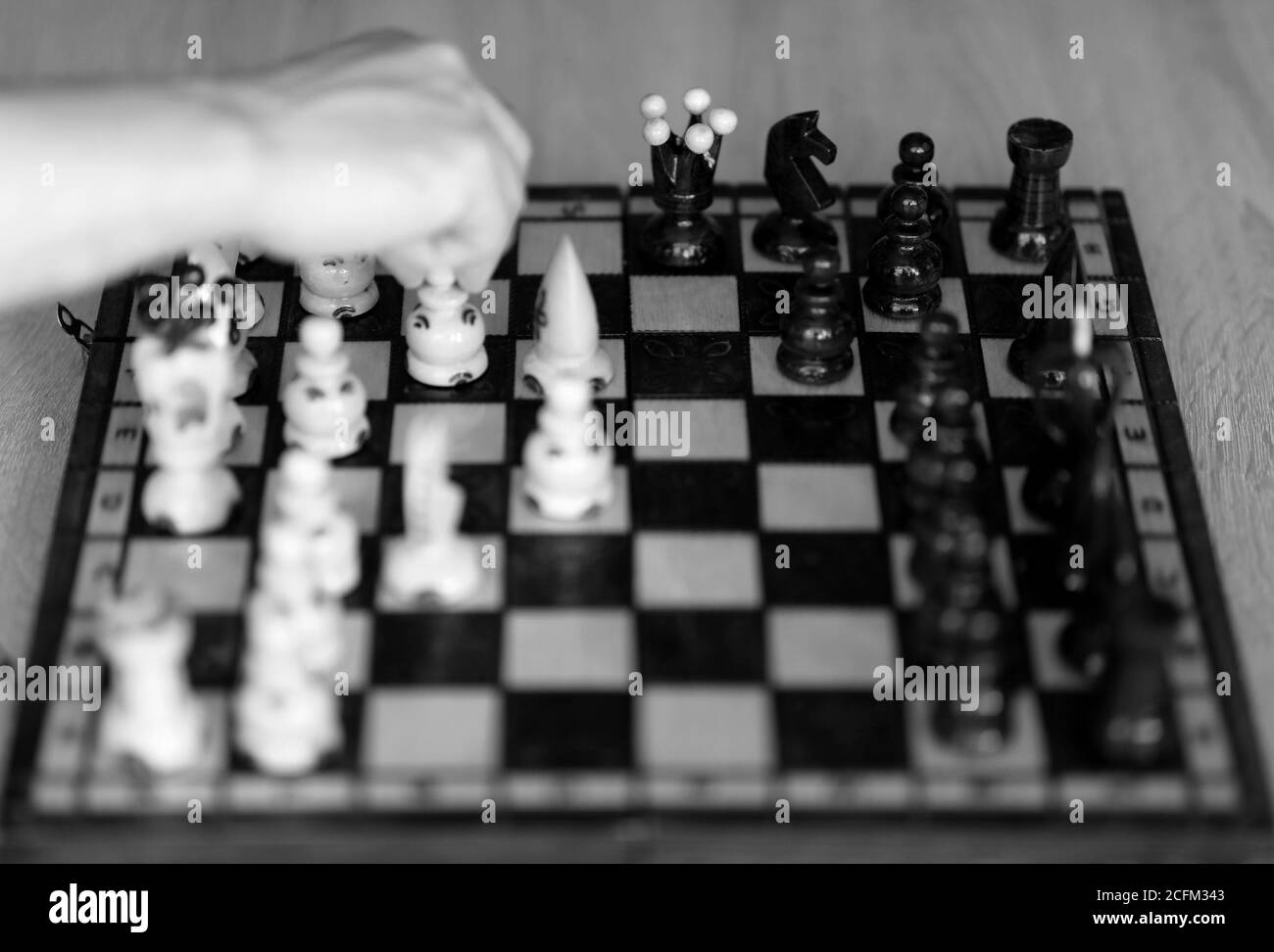 Main du joueur d'échecs dans la décision couleur noir et blanc. Banque D'Images