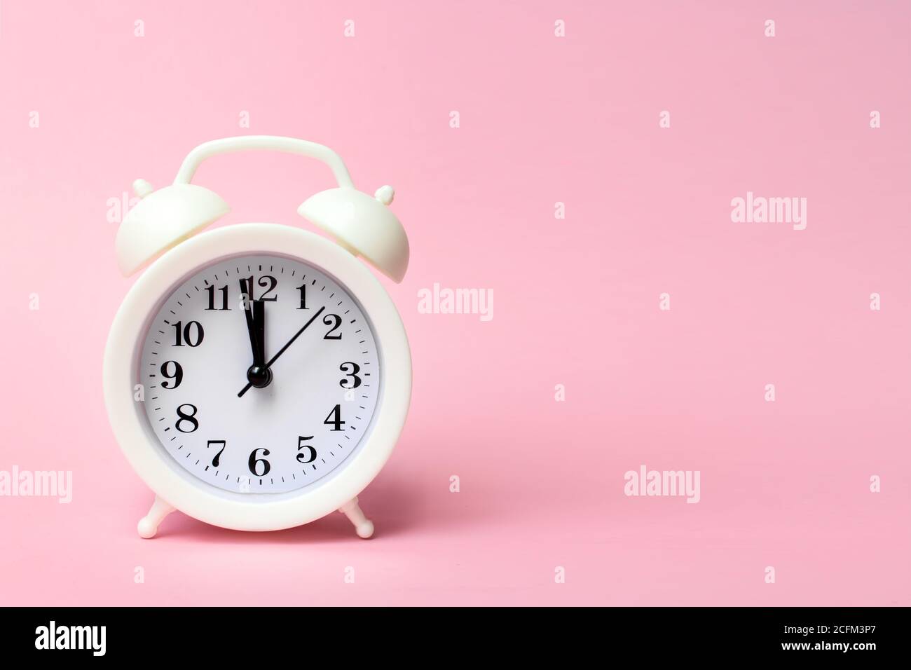 Réveil blanc sur fond coloré. Style minimaliste tendance. Beauté et mode. Composition de la pose à plat. Vue de dessus Banque D'Images