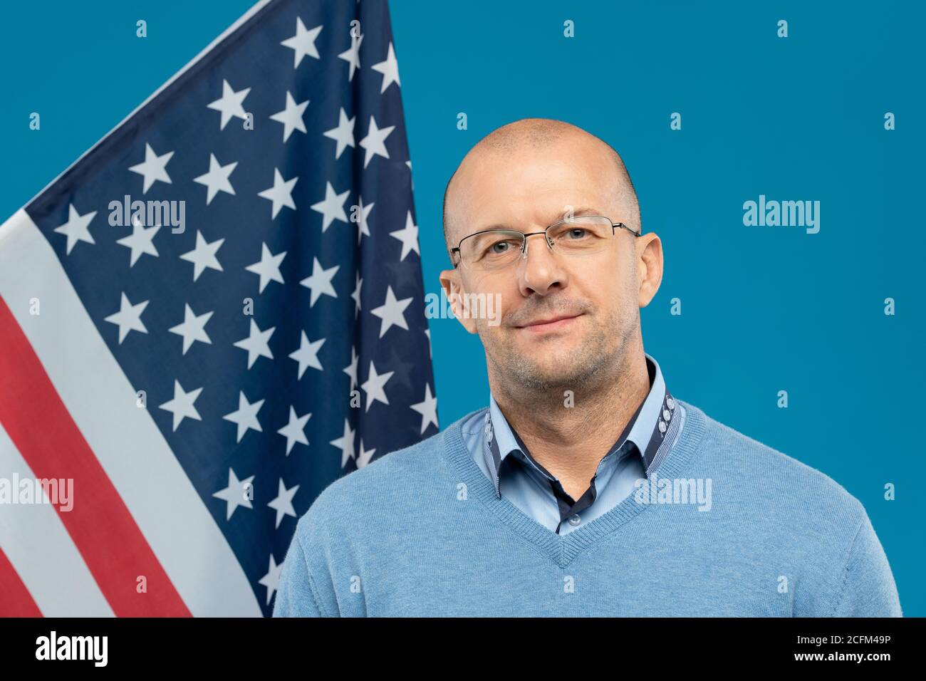 Avocat ou homme d'affaires confiant d'âge moyen dans les lunettes et pull-over bleu Banque D'Images