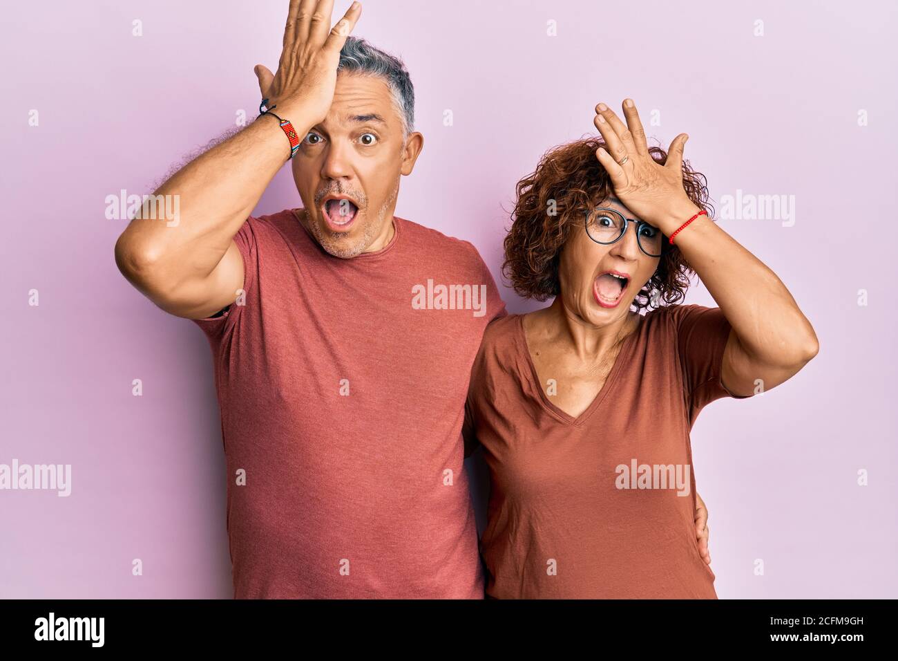 Beau couple d'âge moyen ensemble portant des vêtements décontractés surpris avec la main sur la tête pour l'erreur, souvenez-vous de l'erreur. oublié, mauvais concept de mémoire. Banque D'Images Beau couple d'âge moyen ensemble portant des vêtements décontractés surpris avec la main sur la tête pour l'erreur, souvenez-vous de l'erreur. oublié, mauvais concept de mémoire. Banque D'Images