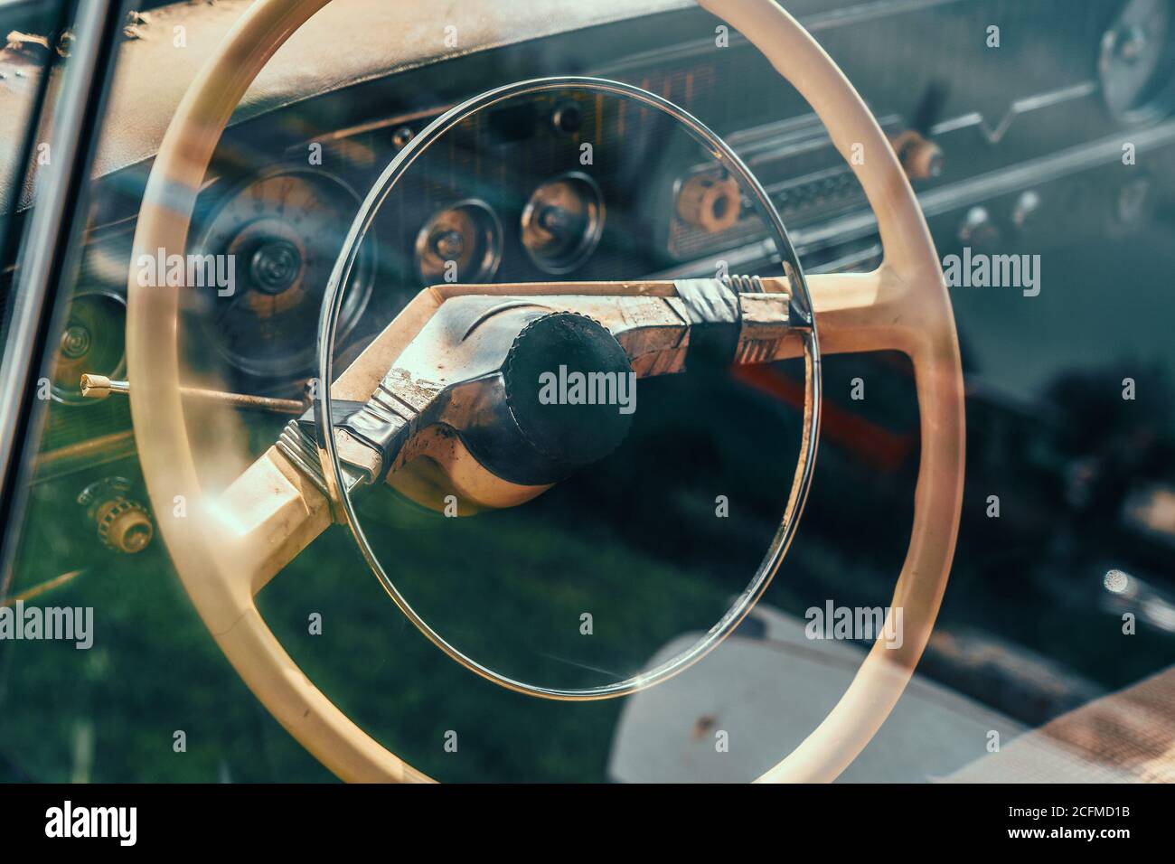 Volant de l'ancienne voiture rouillée abandonnée, vue à travers le verre avec réflexion. Banque D'Images