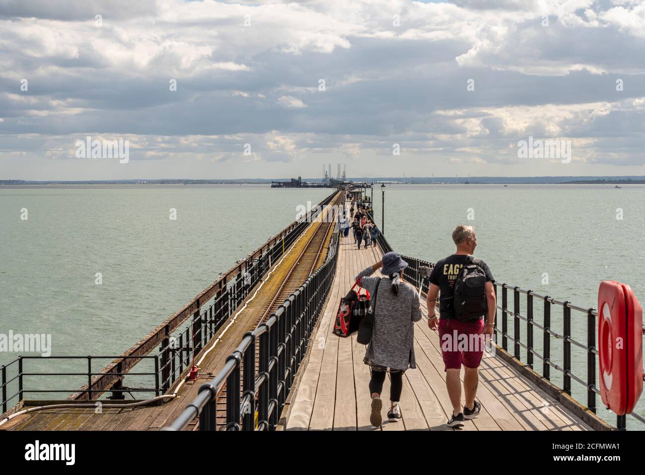 Les personnes qui marchent sur Southend Pier, se dirigeant vers l'estuaire de la Tamise. Couple, mâle et femelle, sur la passerelle Banque D'Images