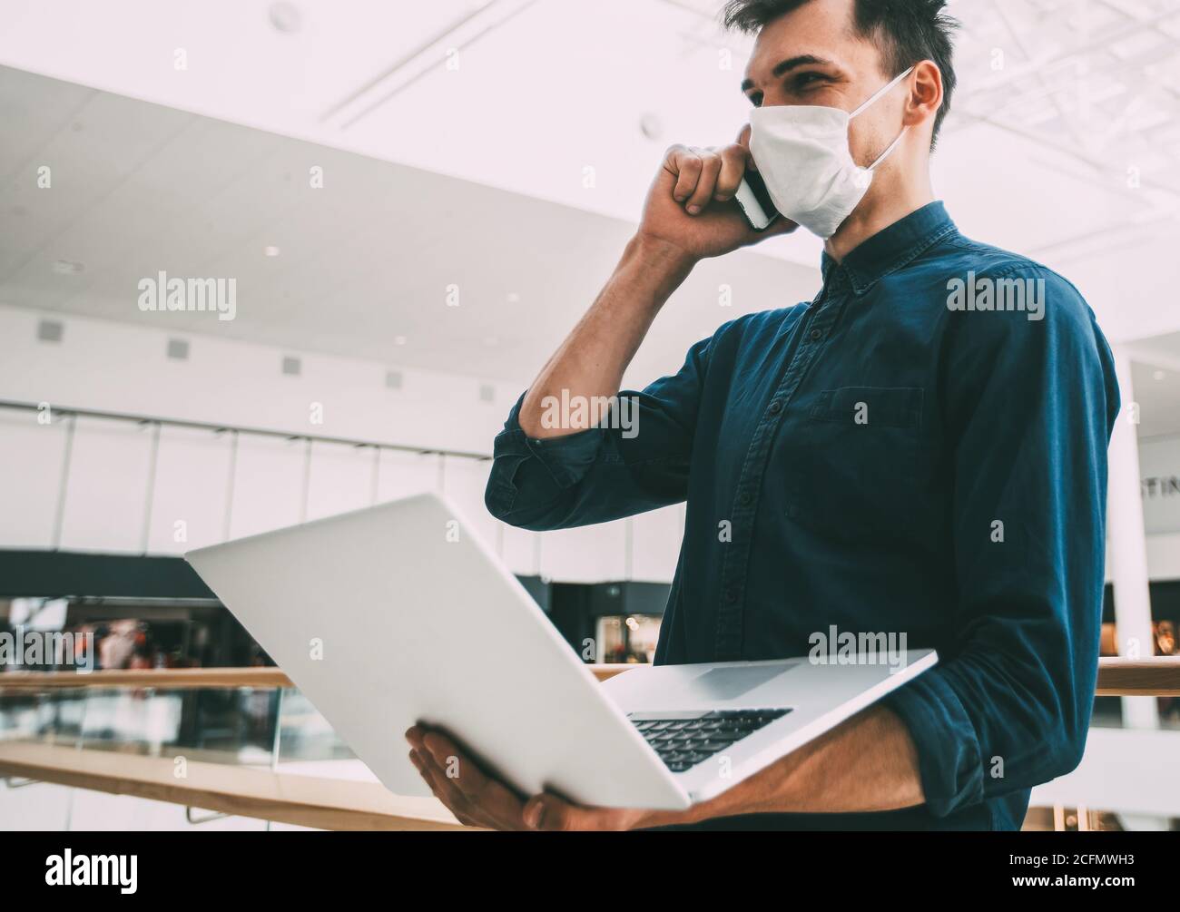 jeune homme dans un masque de protection parlant sur un smartphone. Banque D'Images