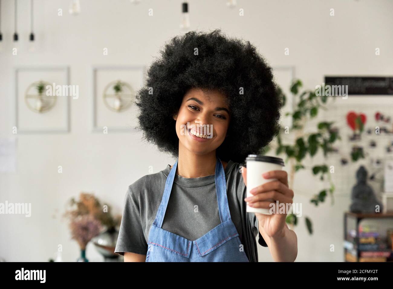 Bonne femme africaine jeune employé de café tenant une tasse de café, portrait. Banque D'Images