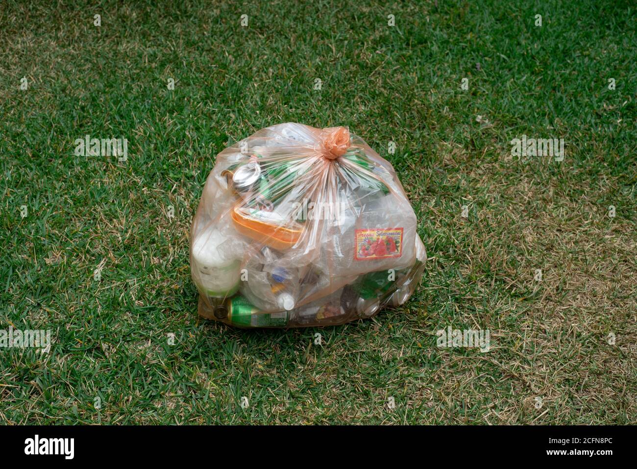 Sac à déchets en plastique transparent attaché rempli de déchets  recyclables mélangés reposant sur l'herbe et prêt à être ramassé Photo  Stock - Alamy