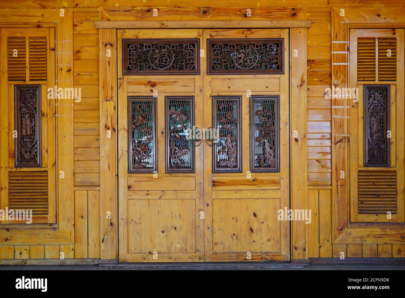 Belle et intrigue porte et fenêtre en bois avec sculpture orientale et ton terre. Banque D'Images