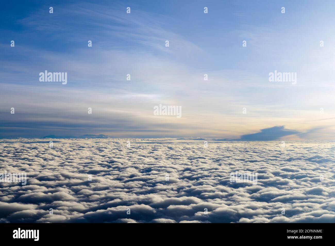 Au-dessus des nuages de lever du soleil depuis la fenêtre de l'avion Banque D'Images