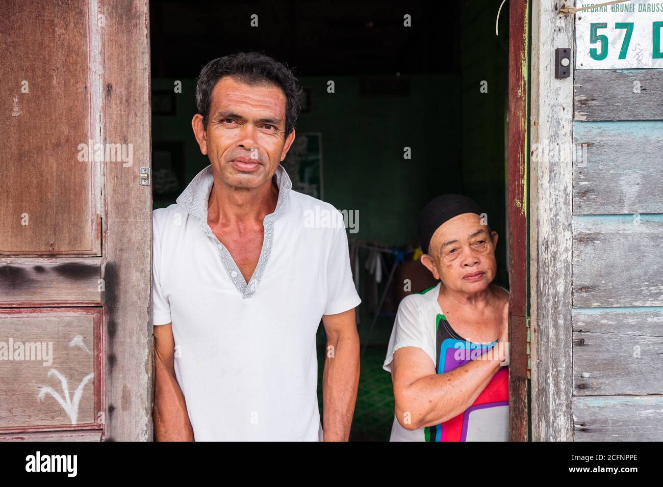 Bandar Seri Begawan / Brunei - 16 janvier 2019: Grand-mère et homme posant à la porte en bois de la maison dans le village flottant de Kampong Ayer Banque D'Images