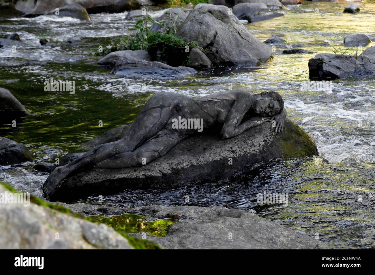 Nature Art: Pierre dans la rivière bodypainting et photoshooting avec le modèle Daniela sur une pierre dans la rivière Chemnitz à Schweizerthal le 6 septembre 2020 - Bodypainting artiste: Joerg Duesterwald Banque D'Images
