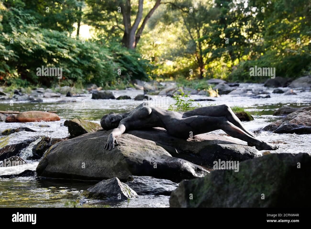 Nature Art: Pierre dans la rivière bodypainting et photoshooting avec le modèle Daniela sur une pierre dans la rivière Chemnitz à Schweizerthal le 6 septembre 2020 - Bodypainting artiste: Joerg Duesterwald Banque D'Images