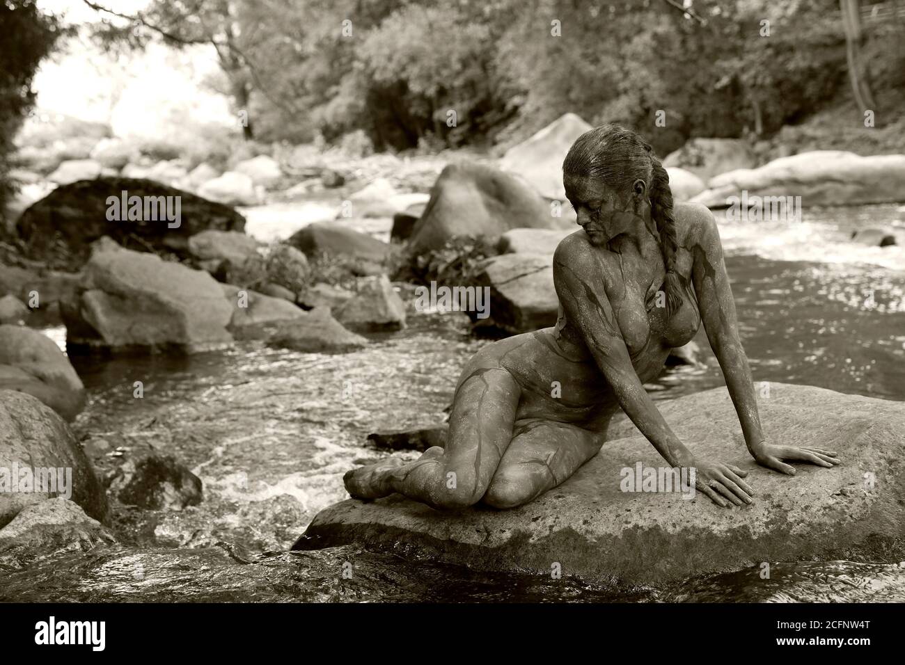 Nature Art: Pierre dans la rivière bodypainting et photoshooting avec le modèle Daniela sur une pierre dans la rivière Chemnitz à Schweizerthal le 6 septembre 2020 - Bodypainting artiste: Joerg Duesterwald Banque D'Images