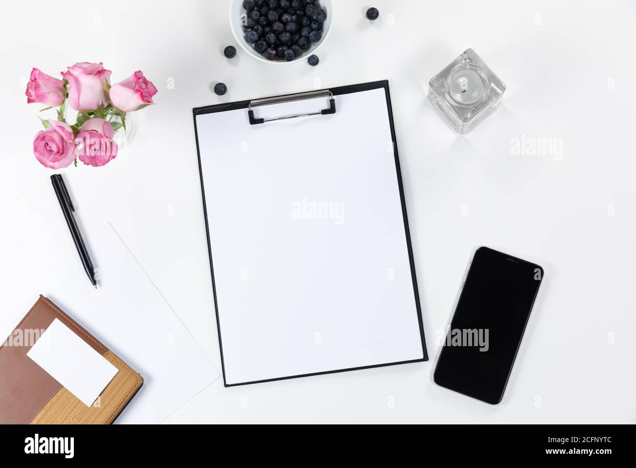 Vue sur un ordinateur portable et un téléphone avec fleurs et parfum sur fond blanc Banque D'Images