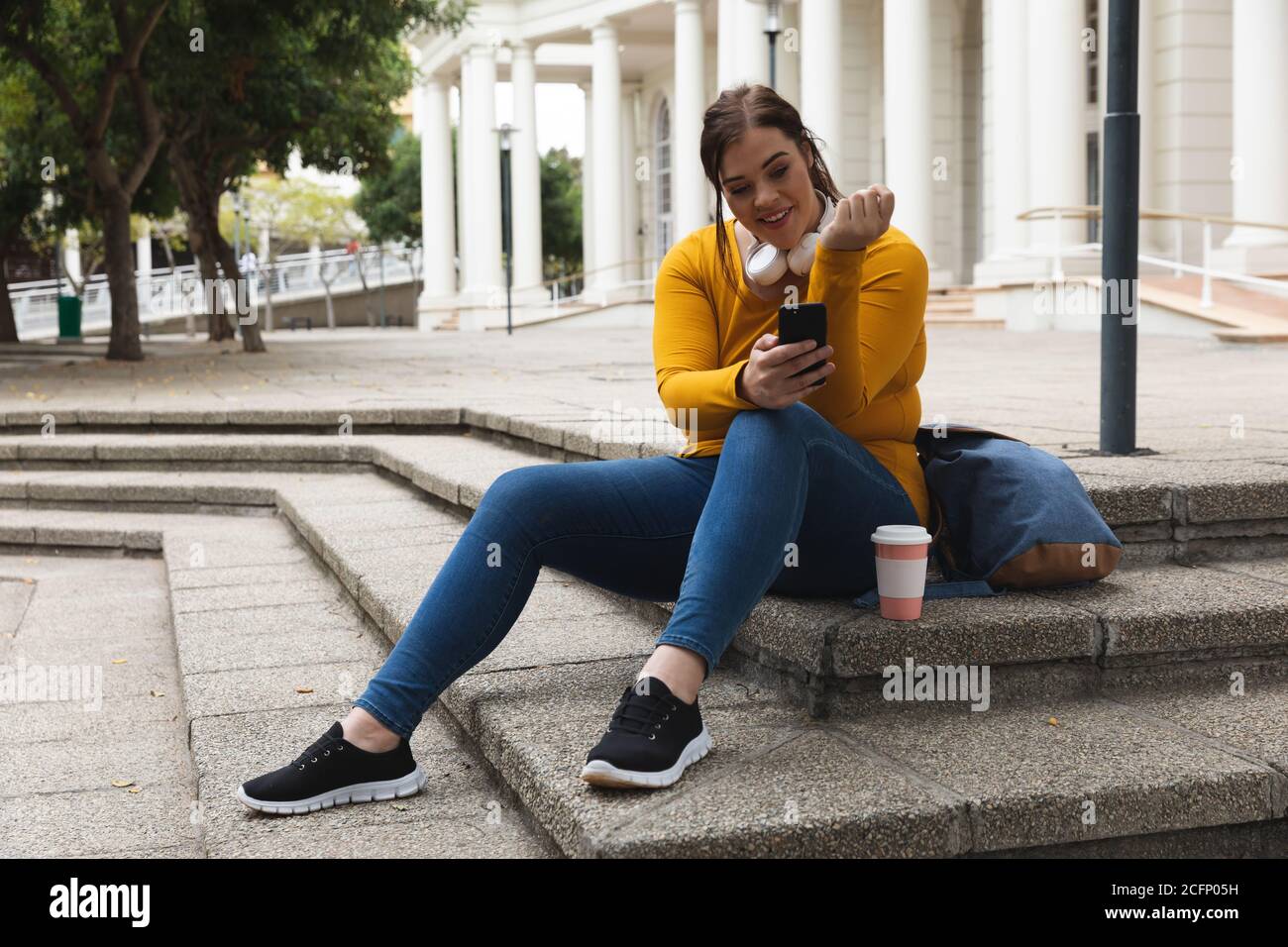 Curvy caucasienne femme utilisant son smartphone dans les rues de la ville Banque D'Images