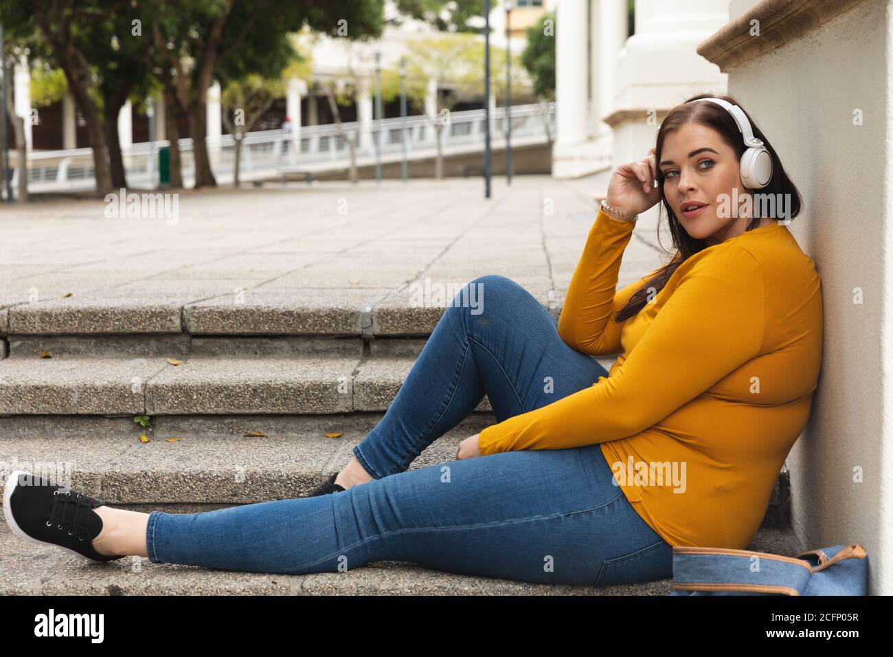 Curvy caucasienne femme écoutant de la musique sur son smartphone Banque D'Images