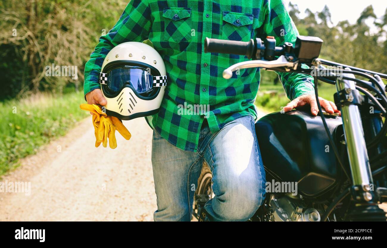 Homme posant avec un casque de moto, gants et Banque D'Images