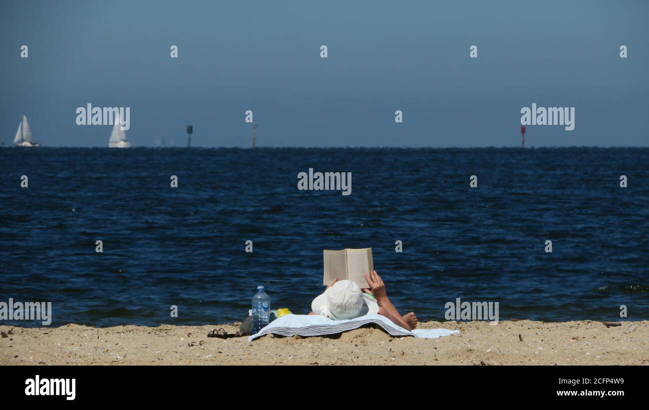 Lecture sur la plage. Détente avec un bon livre au bord de la mer. Banque D'Images