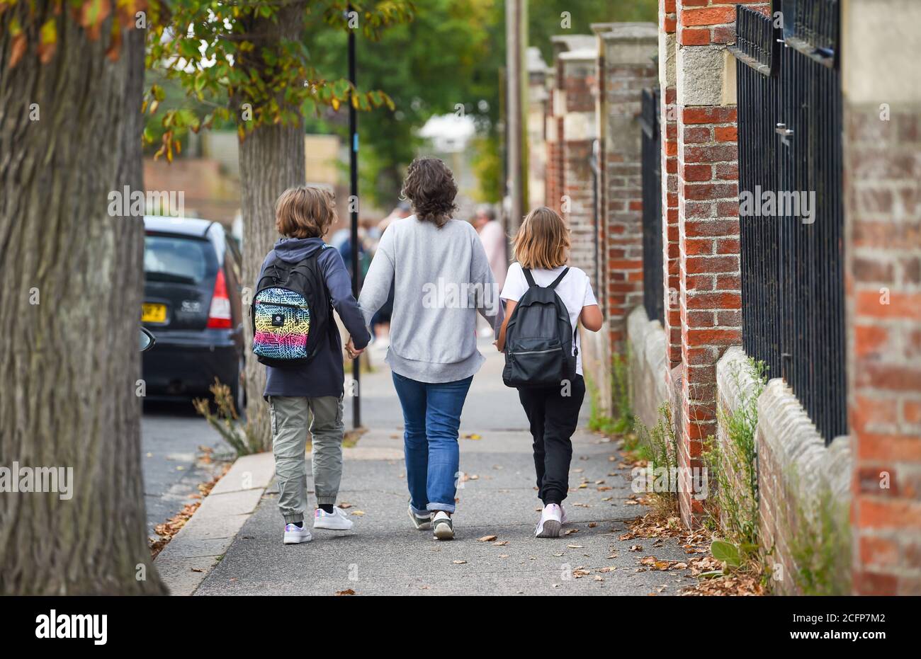 Brighton Royaume-Uni 7 septembre 2020 - Rachael Holdsworth avec ses filles Romy (10) à gauche et Bodil (8) comme élèves et parents arrivent à l'école primaire St Luke à Brighton ce matin où la route a été fermée pour aider à distancer les sociaux et la sécurité routière à leur retour éducation . Le nouveau schéma de rue scolaire a été introduit dans quatorze écoles par le conseil municipal pour le début du mandat en septembre et est appliqué deux fois par jour pendant une heure entre 8-2-4 heures et 18 heures : crédit Simon Dack / Alamy Live News Banque D'Images