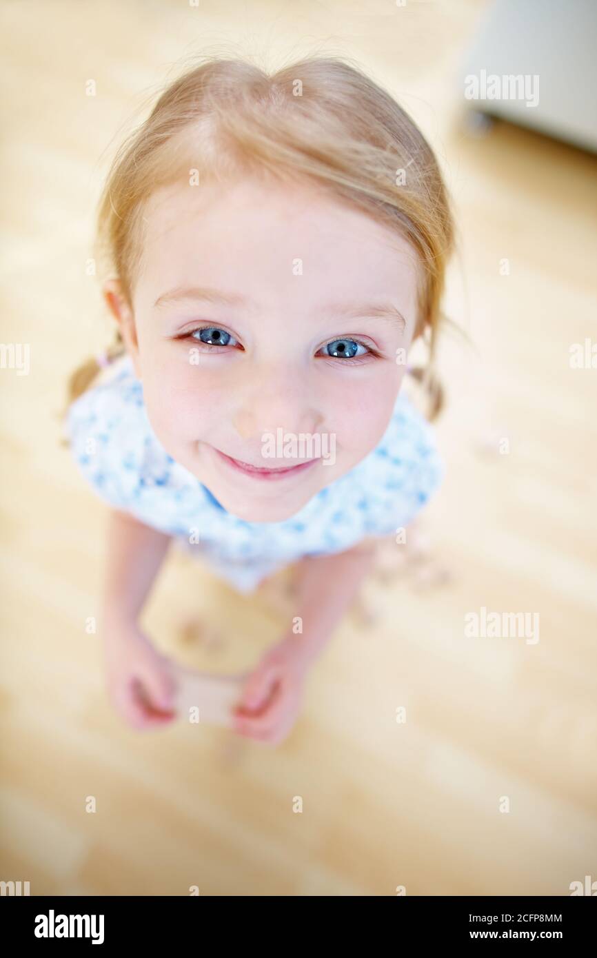 Joyeux enfant qui se grince en regardant l'appareil photo depuis le haut Banque D'Images