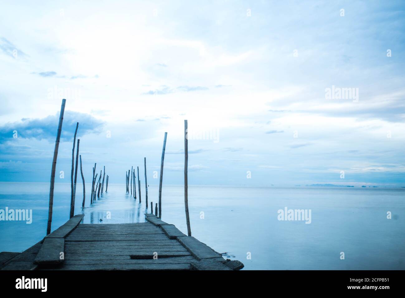 Photographie en longue exposition d'un pont en bois dans la mer bleue Banque D'Images