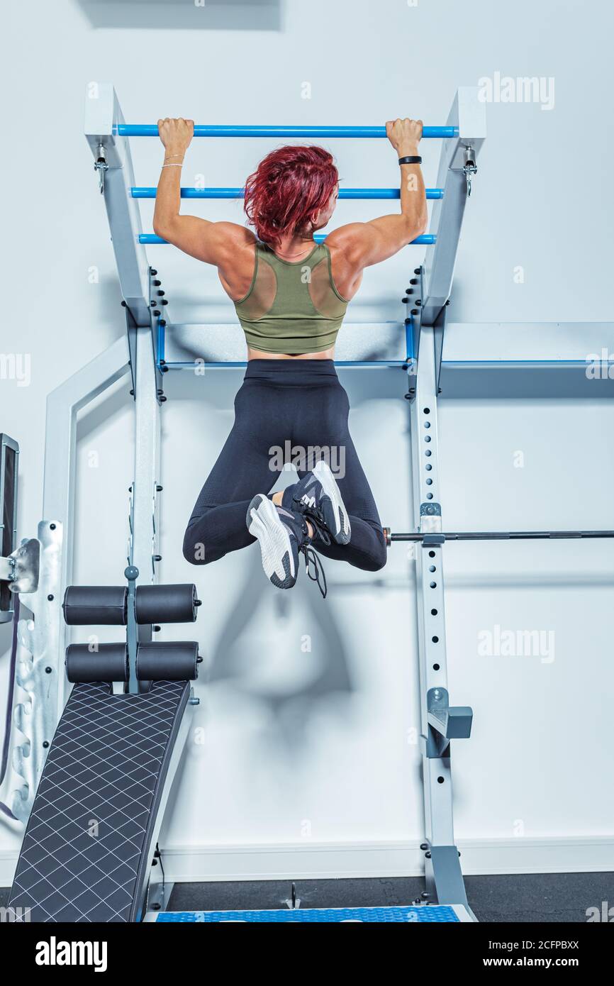 une femme s'entraîner avec un bar dans la salle de gym ou salle de fitness Banque D'Images