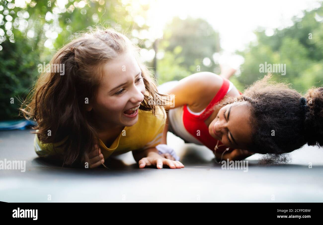 Vue de devant de jeunes filles adolescentes en plein air dans le jardin, riant. Banque D'Images