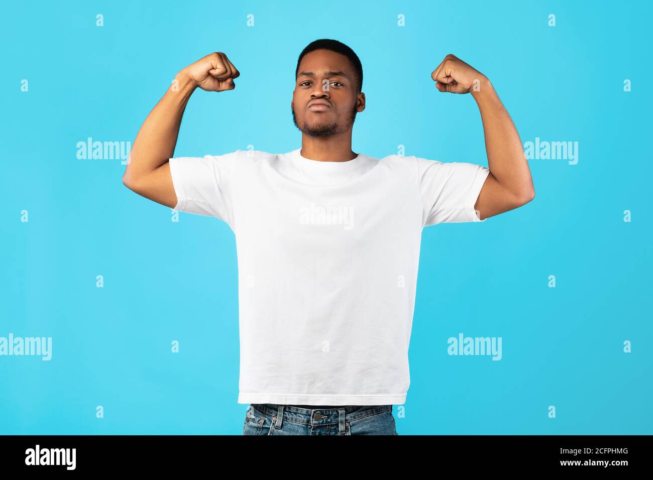 Homme noir fort montrant des biceps posant sur fond bleu Banque D'Images