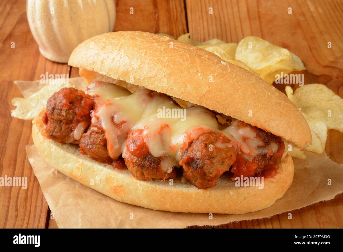 Un sandwich au meatball avec des chips de pomme de terre sur un emballage brun Banque D'Images