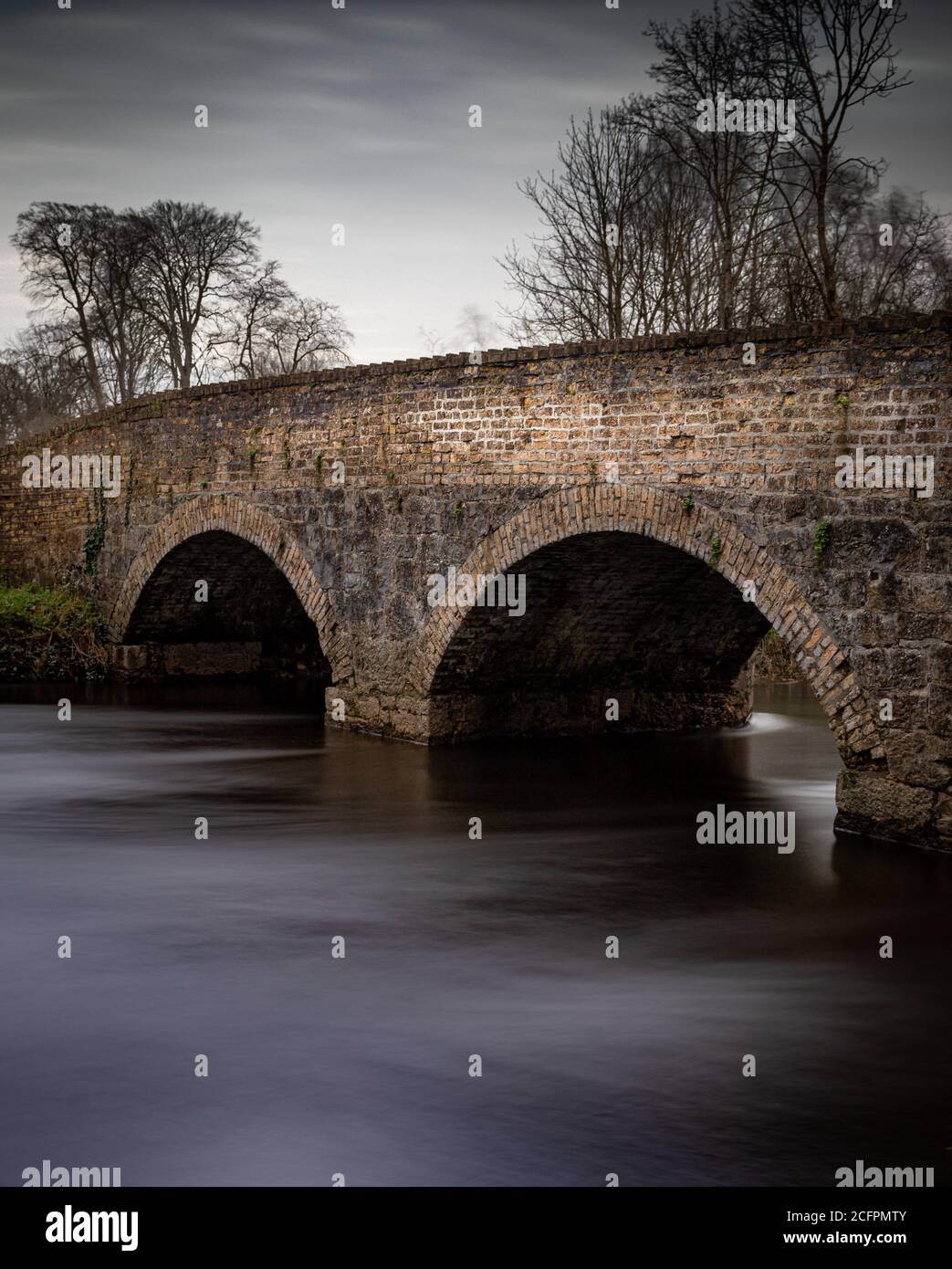 Un pont situé en Irlande avec une rivière lente passage sous Banque D'Images