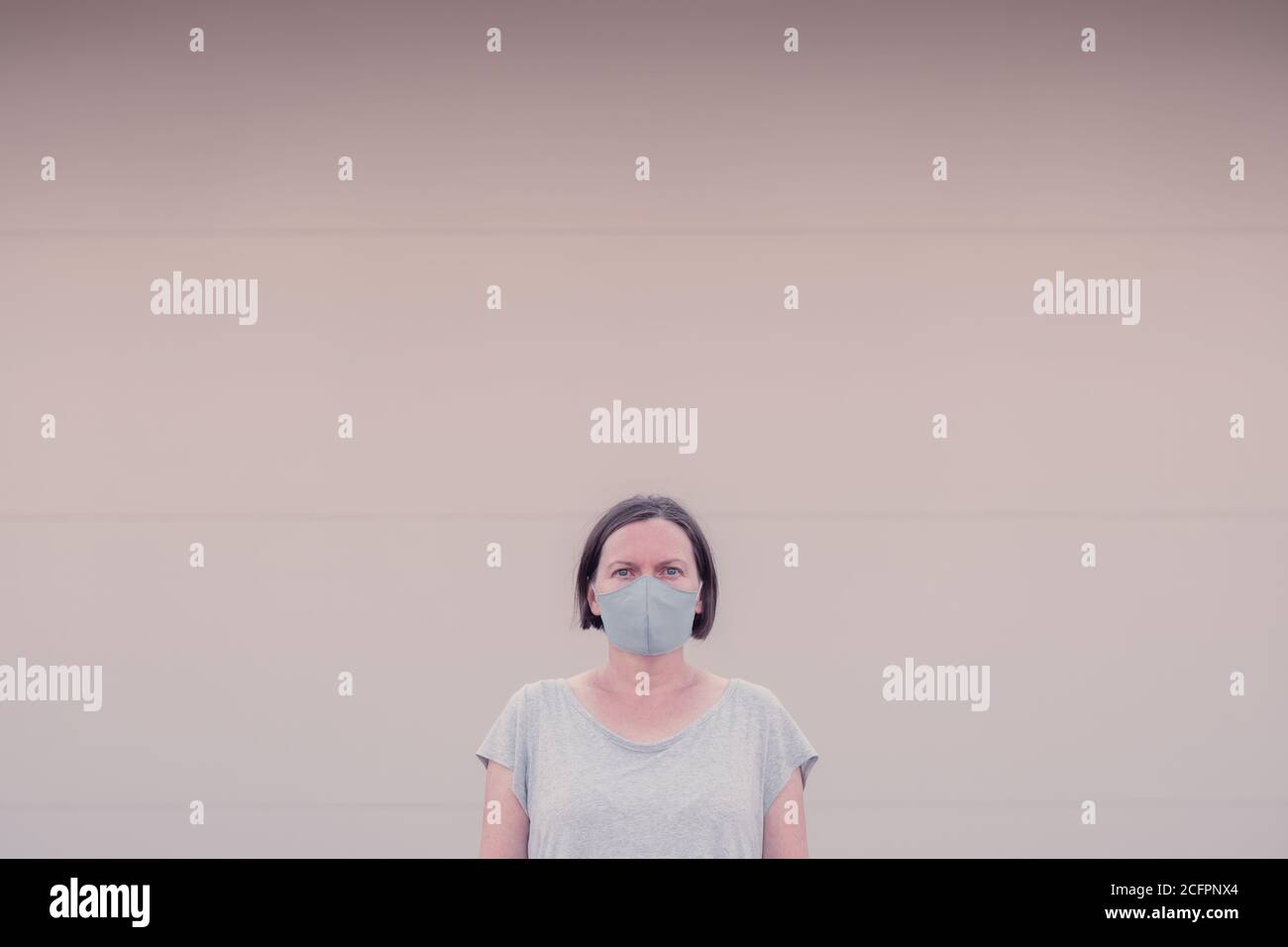 Nouveau portrait normal, d'une femme adulte décontractée avec masque protecteur debout seul dans la rue Banque D'Images