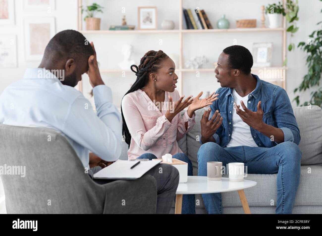 Crise du mariage. Les jeunes conjoints noirs se disputent lors de la séance de thérapie familiale Banque D'Images