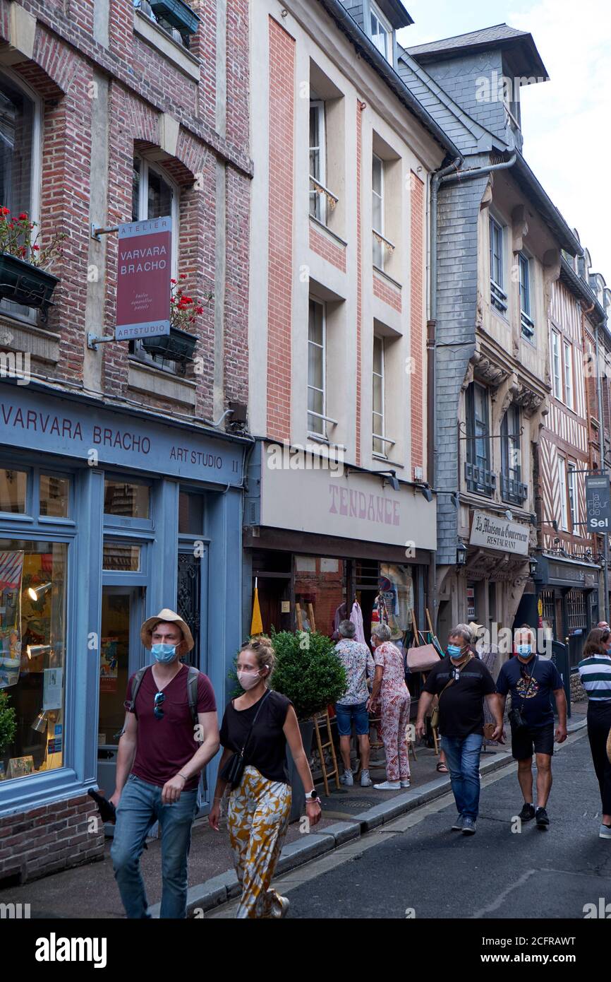 Vacanciers et touristes dans la rue commerçante portant des masques de visage pendant La pandémie COVID-19 dans la pittoresque ville portuaire de Honfleur En Normandie Banque D'Images