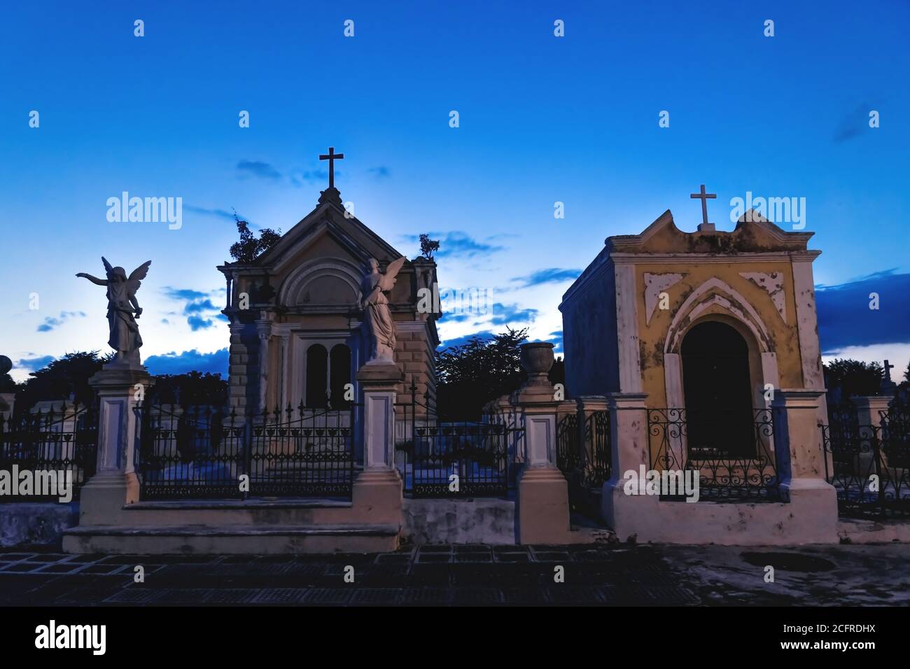 Tombes de cimetière avec des cadavres et des statues d'ange au crépuscule bleu éclairé au cimetière 'Cementerio General' de Merida, Yucatan, Mexique Banque D'Images