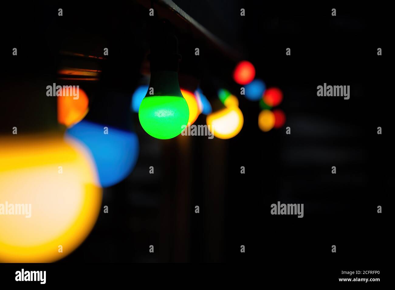 Des ampoules colorées bokeh arrière-plan avec espace pour le texte. Guirlande lumineuse festive verte, jaune, bleue et rouge, idéale pour les fêtes ou les fêtes de Noël Banque D'Images