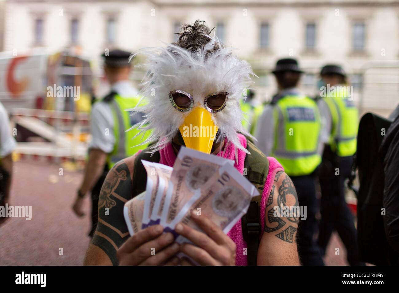 Homme dans un masque d'oiseau avec billets en espèces, manifestation de la rébellion d'extinction du « Carnaval de la corruption », Londres, 3 septembre 2020 Banque D'Images