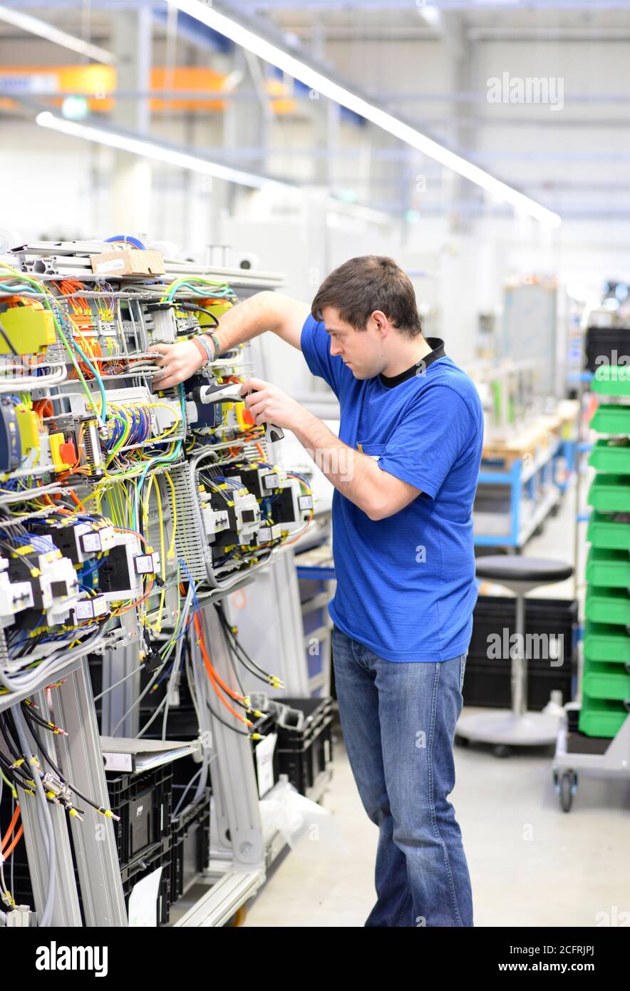 jeune apprenti travailleur dans une entreprise industrielle qui assemble des composants électroniques dans l'ingénierie mécanique d'une usine moderne Banque D'Images