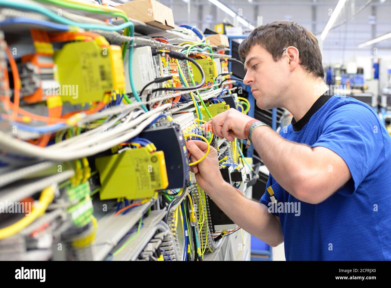 Homme assemble les composants électroniques sur une machine dans une usine de mécanique Banque D'Images