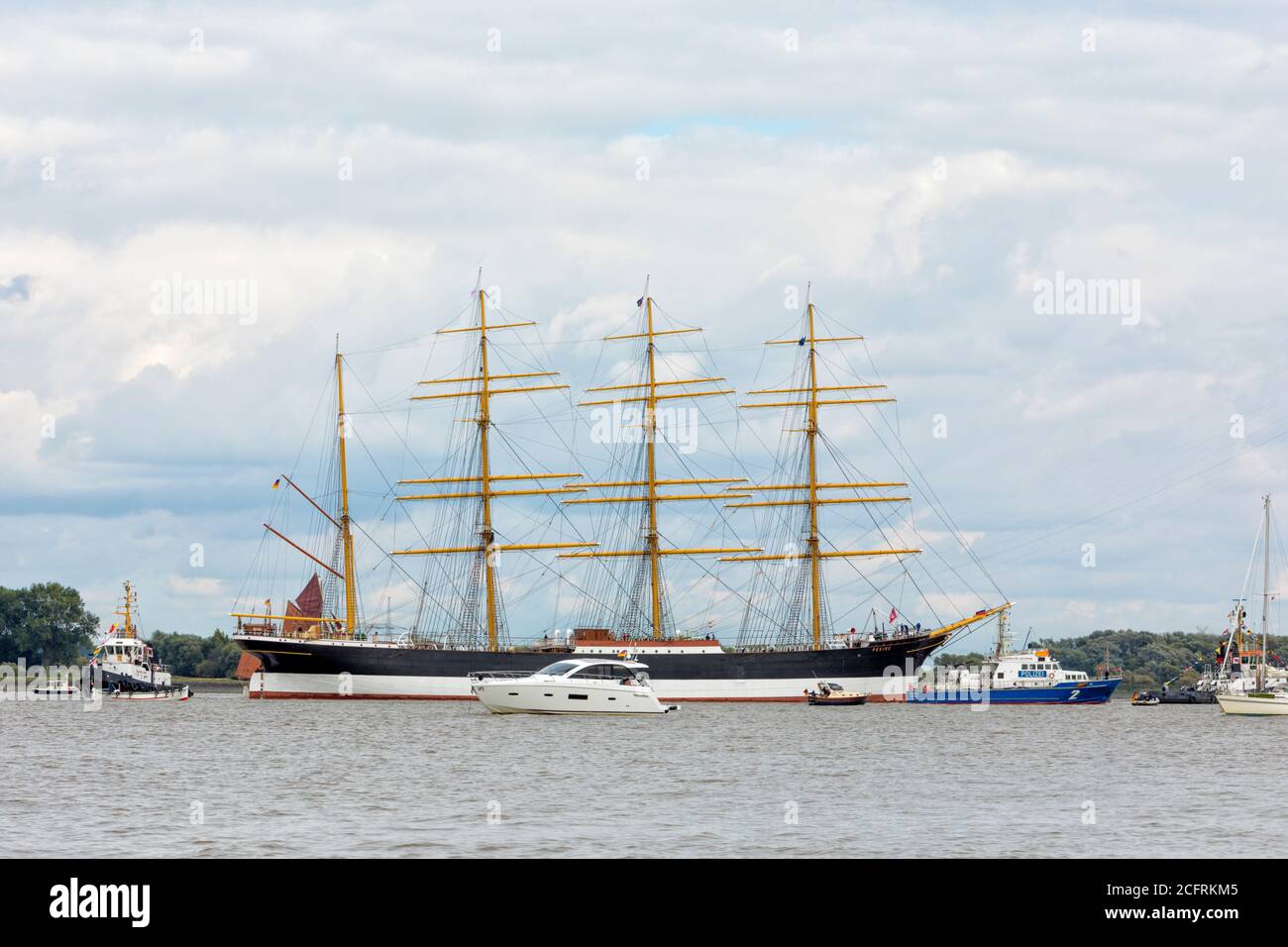 Hollern-Twelenfleth, Allemagne - 7 septembre 2020 : barque historique DE PÉKIN sur l'Elbe en train d'être remorqué au Musée du port allemand à Hambourg, accompagné d'un bateau de police et de spectateurs sur de petits bateaux Banque D'Images